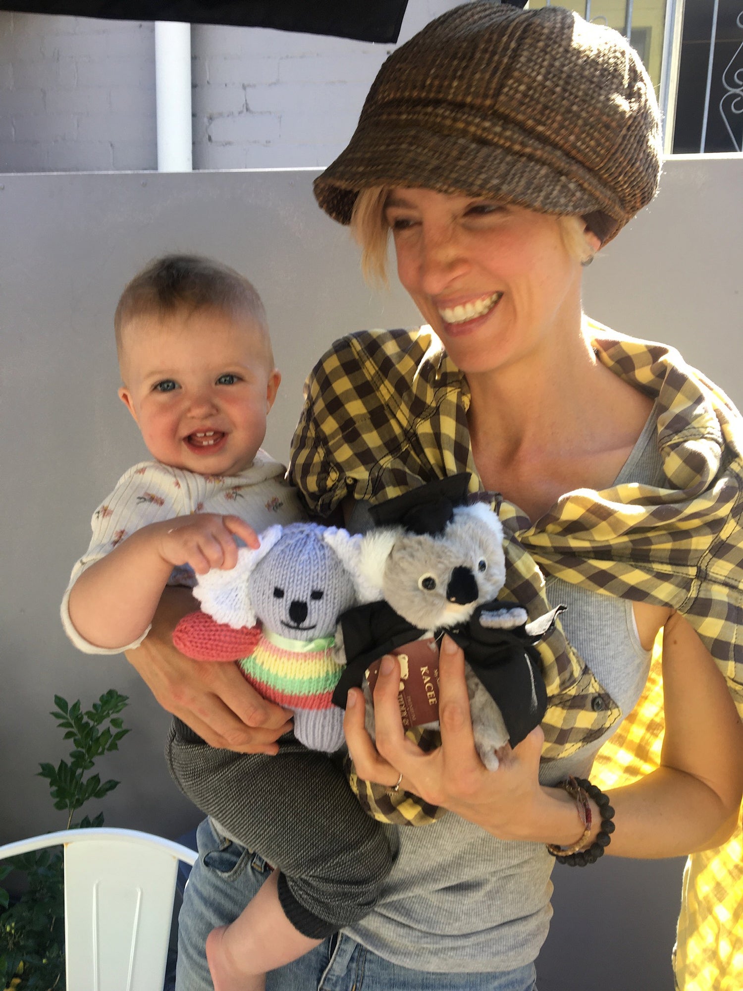 Owner Juliet wearing hat with hair, holding baby daughter