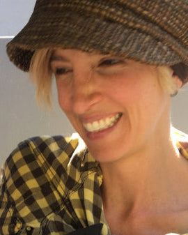 Owner Juliet wearing hat with hair, holding baby daughter