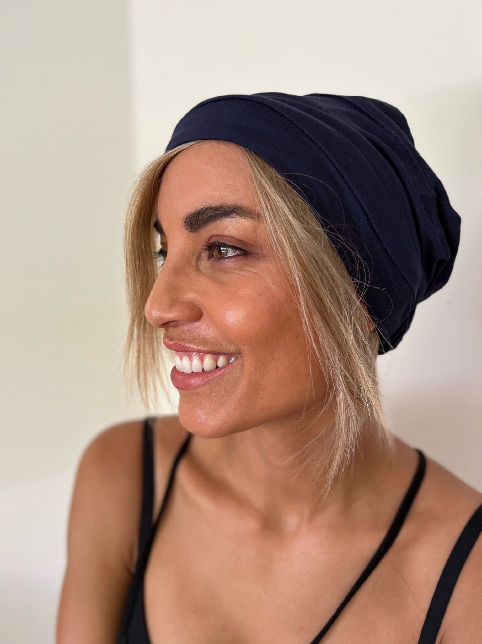 Model wearing black bamboo beanie with hair attached in honey blonde human hair