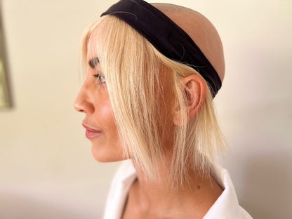 Bald woman wearing blonde headband hat wig without a hat