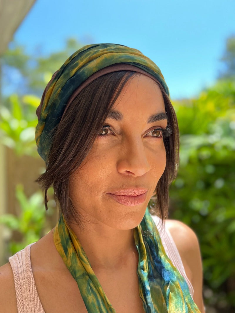 Woman wearing dark brown human hair half wig for cancer patients - worn under brown softie with green scarf
